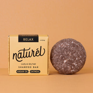 Round RELAX shampoo bar beside yellow packaging